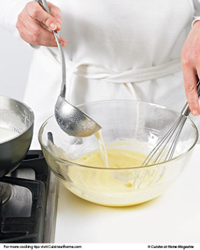 To avoid curdling, temper the egg yolks by slowly adding some of the steaming milk mixture while whisking constantly.