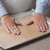 For a smooth, even layer, press dough with waxed paper.