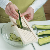 Use a mandoline held over a bowl to cut the cucumber into very thin, even strips. If you don't have a mandoline, slice the cucumbers with a knife. 