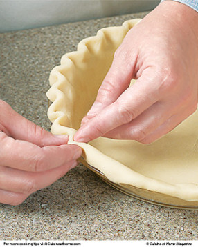 Turn trimmed edges under, then crimp by gently forming the dough around the tip of your finger.