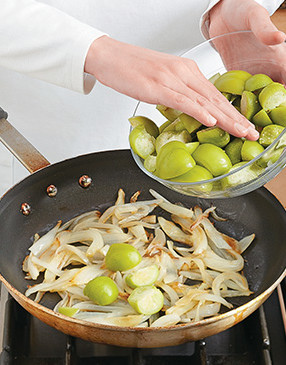 Add the tomatillos to the onions and simmer to enhance their flavor and soften the skin.