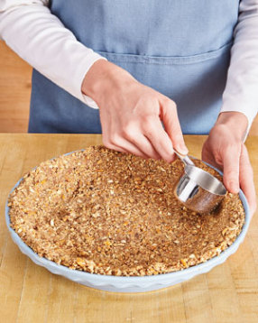 Firmly press the crumbs into the pie plate to ensure the crust holds together when slicing the pie.