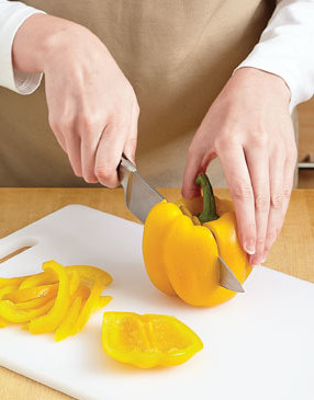 To cut a bell pepper for easy slicing, stand it on its end and cut off the four lobes around the stem.