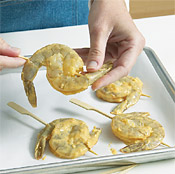 Thread 2 shrimp onto skewers, curling them around each other so that the tails are at opposite ends.