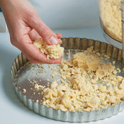 Scatter the crumbly dough in the tart pan, making sure to spread it into the corners. 