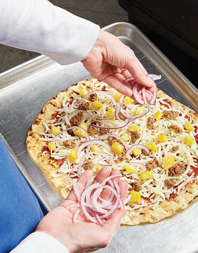 To prevent the crust from getting soggy and weighed down, top the pizzas evenly and lightly.