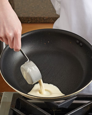 Once skillet is HOT and brushed with melted butter, pour the batter to the side using a ¼ cup measure.