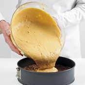 Pour the filling into the cooled prebaked crust. Shake the pan to level the cheesecake filling.