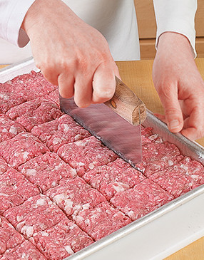 A bench knife is a helpful tool for portioning the meat before cutting it into patties for the sliders.
