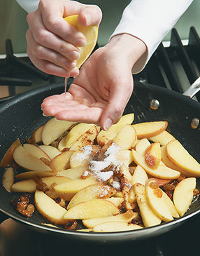 Squeeze lemon over apples &mdash; cup your hand over the pan to keep seeds out of the mixture.