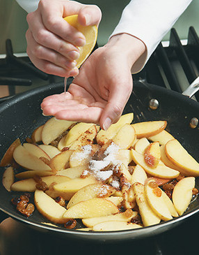 Squeeze lemon over apples — cup your hand over the pan to keep seeds out of the mixture.