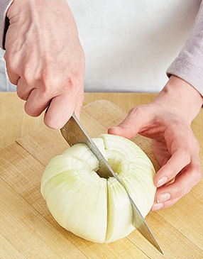 Slicing up to, but not going through the root end, quarter the onion from the blossom end, and slice each quarter into thirds.