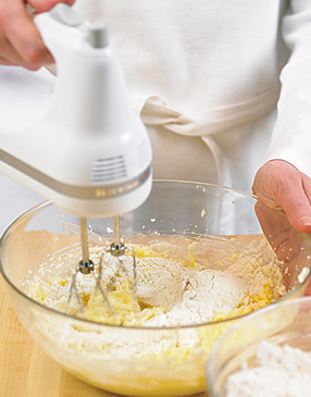 Beating in the flour mixture in two batches allows for more even incorporation into the dough.