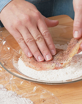 After slicing and pounding chicken into cutlets, season them with salt and pepper and dust with flour.