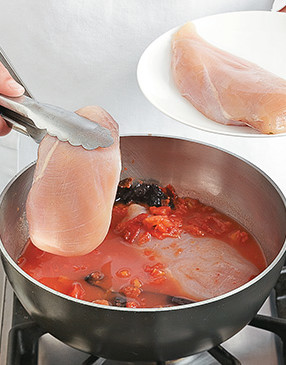 To add flavor to the chicken breasts, poach them in broth with the tomatoes and chiles.