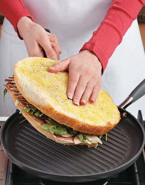 Slide a spatula underneath the panini with your hand placed gently on top, then flip it over.