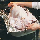 Position the pan so that the turkey&rsquo;s legs point toward the back of the oven where it&rsquo;s hottest.