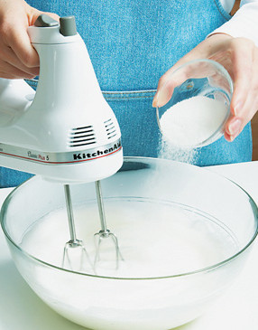 Gradually add sugar to egg white, beating with an electric mixer on high speed until stiff peaks form.
