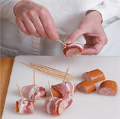 Wrap kielbasa with thin-sliced bacon because it will crisp and fully cook in the allotted roasting time.