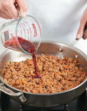 Using red wine to deglaze the pan adds lots of color and flavor to the sirloin and sausage.