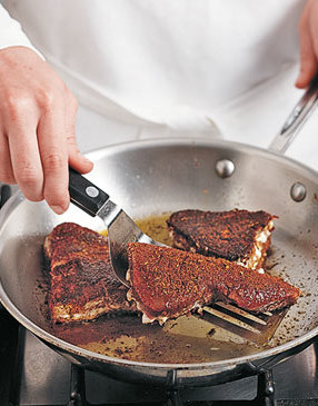 Blacken tuna steaks in a hot skillet. It's OK if they don't cook through, they'll finish cooking in the oven.