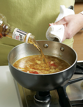 Add bourbon to the sauce off heat. High-proof alcohol will ignite if exposed to a flame.
