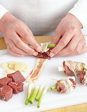 Roll each beef chunk with bacon to hold the bites together. Use thin-sliced bacon so it cooks quickly.