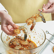 Thread marinated shrimp onto skewers going through the tail and head to hold them in place.