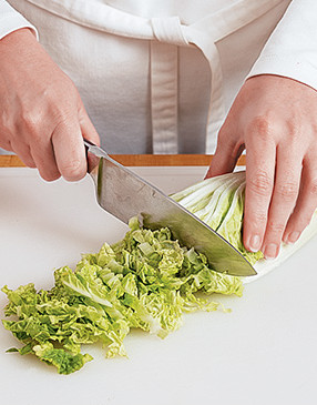 To shred napa cabbage, halve the head lengthwise, then thinly slice, discarding the root end.