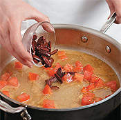 Add olives to the pan with broth, tomatoes, and lemon juice to make a sauce for the chicken.