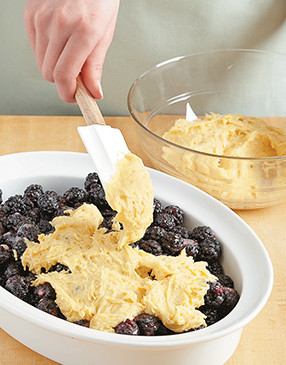 Spoon and gently spread the dough over the berries. It will be thin in spots, but it spreads as it bakes.