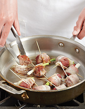 After sautéing the rumaki on all sides, transfer the pan to the oven to finish cooking the meat evenly.