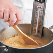 Stir caramel occasionally with a wooden spoon until syrup reaches 250° F on candy thermometer.