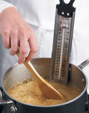 Stir caramel occasionally with a wooden spoon until syrup reaches 250° F on candy thermometer.