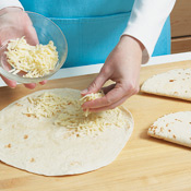 To prepare the quesadillas, sprinkle 1/2 cup cheese on half of each tortilla, then fold over and grill until toasted. 