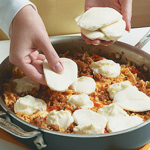 For the finishing touch before broiling, top the lasagna with ricotta and fresh mozzarella.