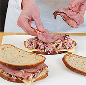 Layer the slaw between the meat and cheese to prevent the rye bread from getting soggy.