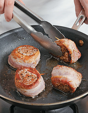 Tip wrapped pork medallions on their edge to cook bacon, rotating as needed to cook all the way around.