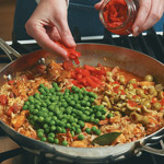 Thaw peas in cold water and drain before adding to the pan. Stir in Spanish olives and pimientos.