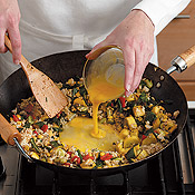 Form a well in the center of stir-fry to scramble eggs. This keeps them contained so they&acute;ll cook faster.