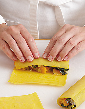 Measure &frac14; cup filling onto each pasta sheet and roll manicotti like a rug, snugly but not too tight.
