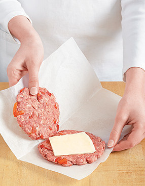 For each burger, top one patty with cheese, and carefully fold the paper so the other patty covers it.