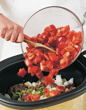 Add raw vegetables to the meat. The juice from the tomatoes will contribute liquid to the chili.