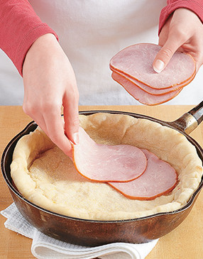 Line the bottom of the crust with ham. It tastes great and acts as a moisture barrier for the filling.