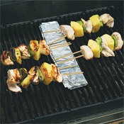 To prevent the ends of the skewers from burning, arrange the exposed end of the skewers over a piece of foil.