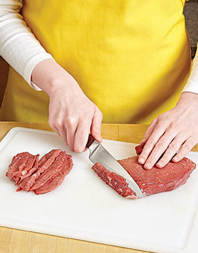 Slicing the steak against the grain into thin strips helps to tenderize it and make it easier to eat.