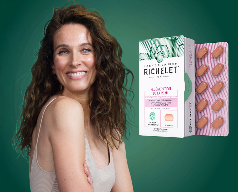 Une femme tenant une capsule RICHELET® Régénération de la peau entre son pouce et son index