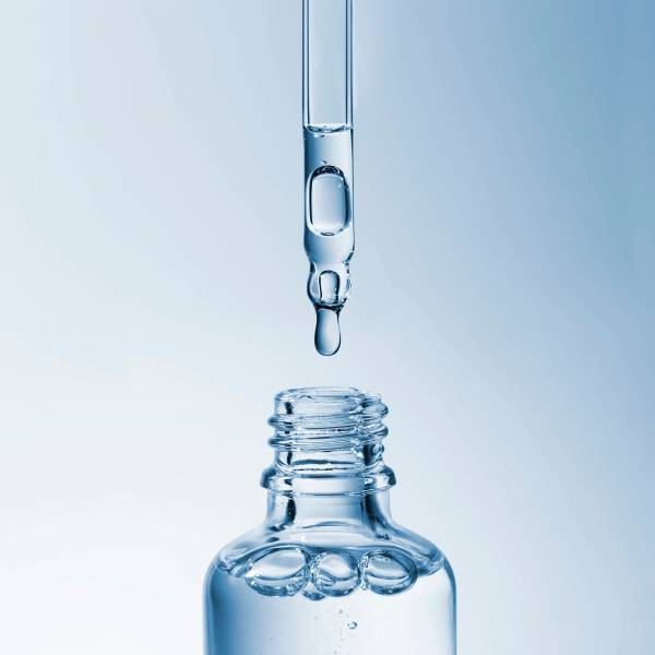 un flacon avec pipette, contenant un liquide clair