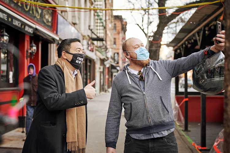 Andrew Yang takes a selfie with a voter on the streets of New York