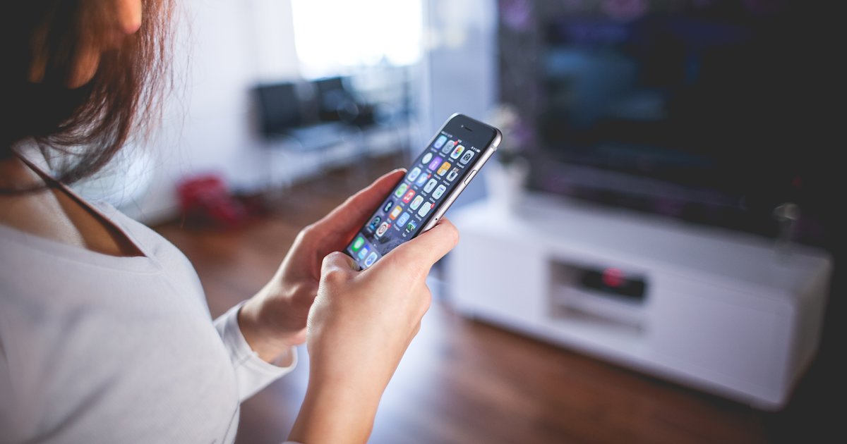 Woman in modern living room using an iPhone